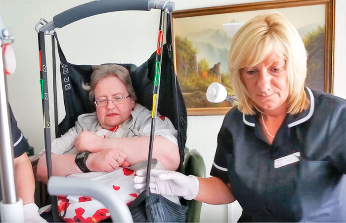 Carer with Margaret in a hoist 1st Homecare - Home Care Visits and Live-in care in Oxford.